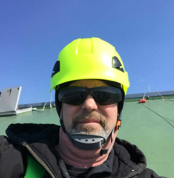 Employee in safety gear working on structural steel testing